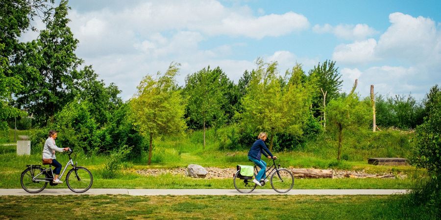 Twee fietsers maken gebruik van een trage weg tussen het groen. Twee fietsers maken gebruik van een trage weg tussen het groen.